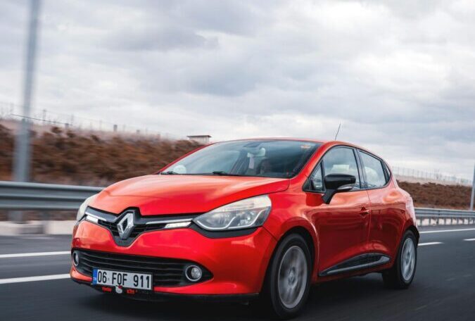 Dynamic shot of a red Renault Clio driving on a highway in Ankara, Türkiye.